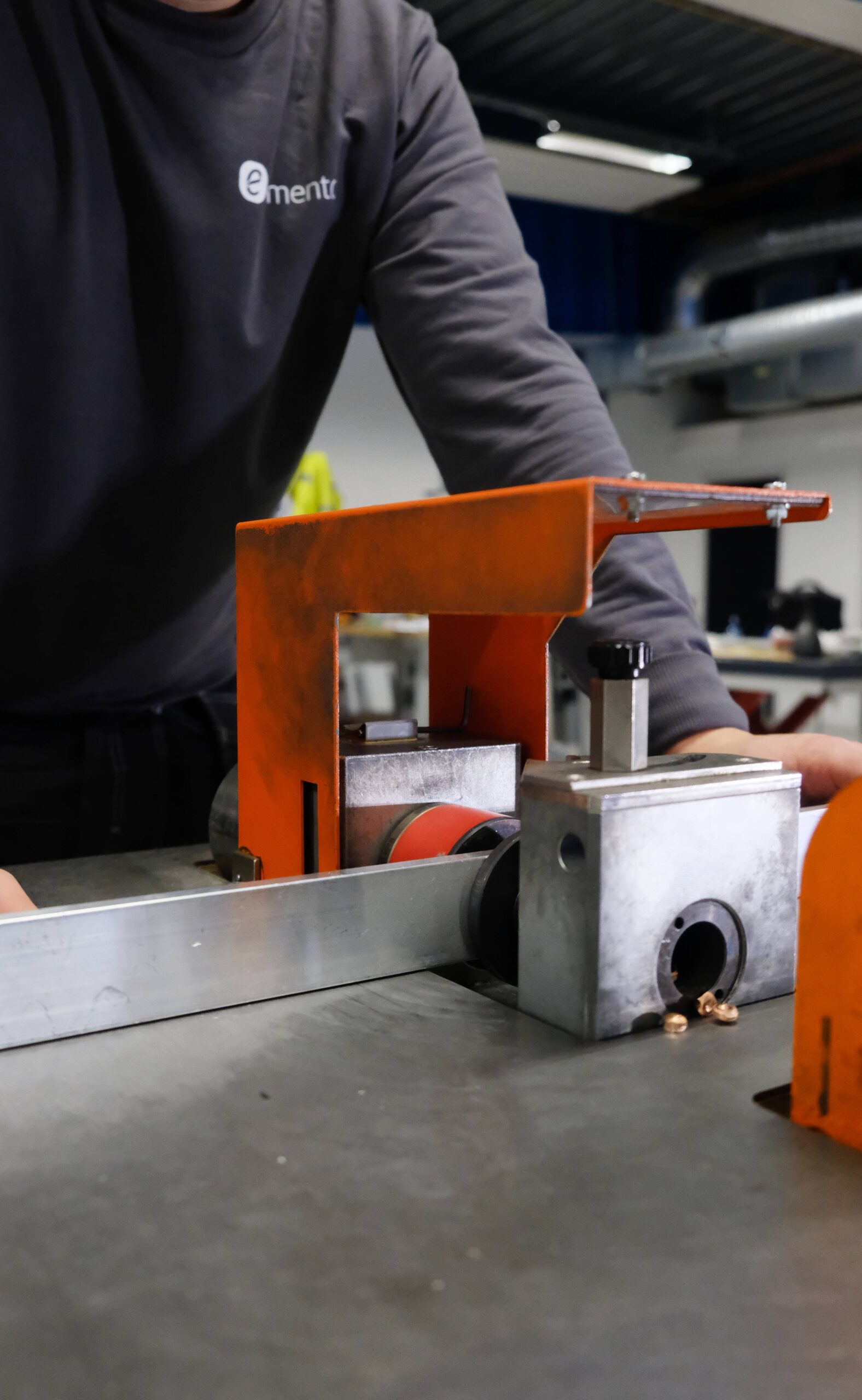 Elmento AS montør bruker en hydraulisk kobber og aluminium bøyer til å stanse hull i en aluminium skinne.